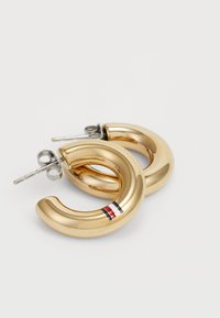 Boucles d'oreilles créoles de couleur or avec une finition lisse et brillante, ornées d'une petite rayure accent rouge, blanche et bleue. Quincaillerie en argent incluse.