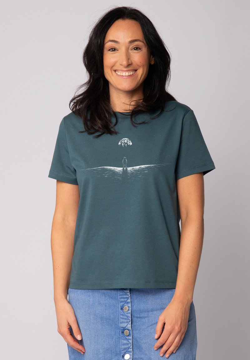 Teal katoenen T-shirt met ronde hals, heeft een witte grafische afbeelding van een figuur en een globe, korte mouwen en een relaxte pasvorm.