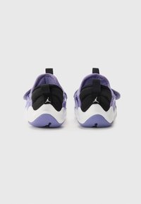 Baskets de sport violettes et noires avec un dessus texturé, semelle blanche et accents noirs. Comprend des languettes pour un enfilage facile.
