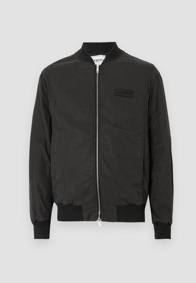 Μαύρο μπουφάν μπομπέρ με φερμουάρ μπροστά, ριμπ μανσέτες και μικρό κεντητό λογότυπο. Κατασκευασμένο από απαλό, ελαφρύ ύφασμα.