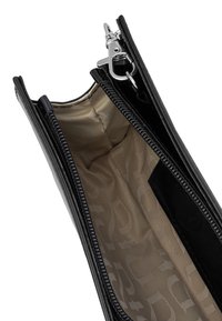 Schwarze Lackleder-Clutch mit einem Reißverschluss, ausgestattet mit einem beigefarbenen Innenfutter, das ein dezentes, sich wiederholendes Muster aufweist, und einem silbernen Metallclip.