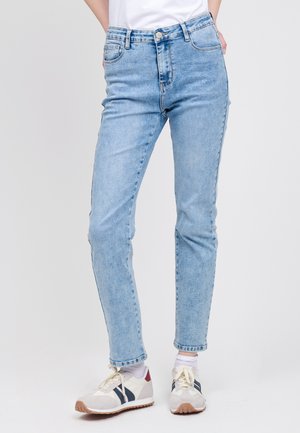 Jean en denim bleu clair à taille haute, coupe slim et texture légèrement délavée. Comprend un design classique à cinq poches et une fermeture à bouton.