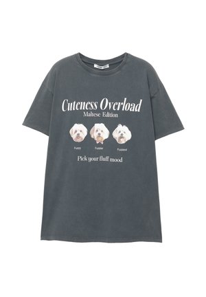 Gray oversized t-shirt featuring three Maltese dog images and the text "Cuteness Overload Maltese Edition" in white print.
