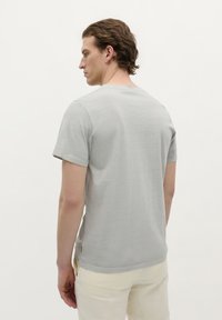 Grijs T-shirt met korte mouwen en ronde hals, met een soepele textuur en een slim fit. De achterkant toont nette stiksels en een ontspannen silhouet.