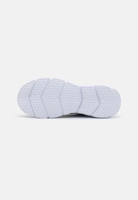 Semelle en caoutchouc blanc de chaussure de sport avec une texture antidérapante, présentant des motifs en zigzag et des micro-textures hexagonales pour un meilleur traction.