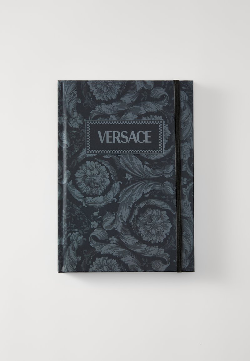 Taccuino rilegato con motivo floreale scuro, con logo Versace centrale in una cornice rettangolare e una fascia elastica di chiusura.