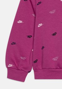 Felpa viola in cotone con loghi Nike ripetuti in nero, bianco e grigio. Presenta polsini e orlo a costina.