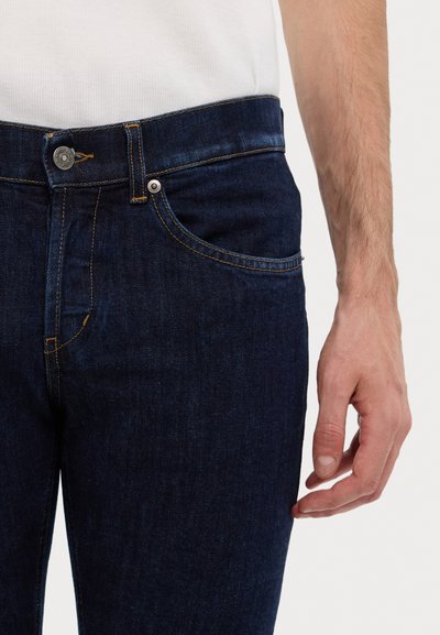 Jeans in denim blu scuro con taglio dritto, cintura con bottoni e delicate cuciture gialle su tasche e cuciture.