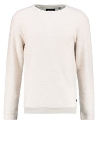 Jasno beżowy sweter z fakturowanej tkaniny, okrągłym dekoltem, długimi rękawami oraz ściągaczami przy mankietach i u dołu. Metka znajduje się blisko dolnego szwu.