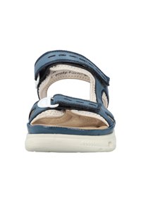 Blå sandal med rund tå, justerbara remmar och en vadderad innersula med ett texturerat mönster. Lättviktig vit yttersula.