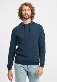 Marineblaues Strickhoodie mit strukturiertem Muster, Kordelzugkapuze und gerippten Bündchen und Saum. Sieht ein schwarzes Logo-Patch auf dem linken Ärmel vor.