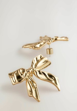 Ohrringe in Goldfarbe, die wie Schleifenbänder geformt sind, mit einer glänzenden Oberfläche und strukturierten Details in der Mitte und an den Rändern.