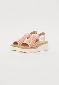 Open-toe sandals with multicolored woven straps in pink and orange, tan leather accents, and a white platform sole with ribbed texture.