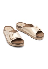 Złote metaliczne sandały na płaskiej podeszwie z szerokim skrzyżowanym paskiem i ozdobną klamrą. Posiadają wyściełaną wkładkę i lekką gumową podeszwę.