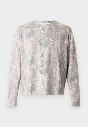 Chemise à manches longues à motif camouflage comprenant des nuances de gris, marron et rose clair. Tissu doux avec une coupe décontractée et un col rond.