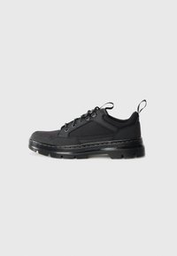 Black low-top sneaker with textured fabric and leather upper, thick ridged sole, metal eyelets, and pull tabs on tongue and heel.