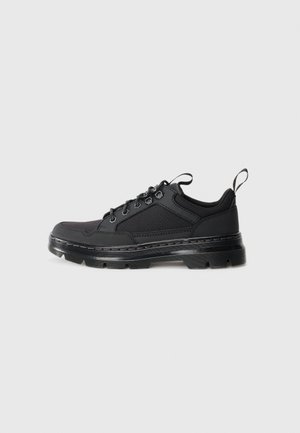 Schwarze Low-Top-Sneaker mit strukturiertem Stoff- und Lederobermaterial, dickem profiliertem Sohle, Metallösen und Anziehschlaufen an Zunge und Ferse.