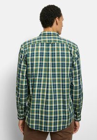 Karierte Langarmbluse in Grün-, Blau- und Gelbtönen mit einem Button-Down-Kragen, abgerundetem Saum und einem einzelnen Knopf am Ärmelabschluss.