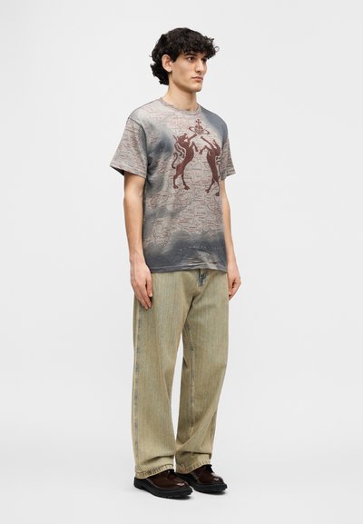 Βαμβακερό μπλουζάκι με γκρι διαβάθμιση και γραφικό σχέδιο σε χρώμα μπορντό. Συνδυασμένο με φαρδιά παντελόνια τζιν σε ανοιχτό πράσινο και σκούρα παπούτσια. Μινιμαλιστικό στυλ.