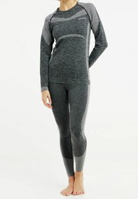 Set di top e leggings atletici grigi, caratterizzato da un tessuto testurizzato, accenti a contrasto e un design aderente per comfort e flessibilità.