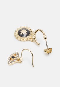 Brincos dourados com uma pedra preta redonda com um design floral e uma forma de gota de água adornada com strass claros.