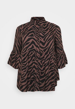 Blouse boutonnée avec rayures zèbre noires et marron, manches larges trois-quarts et col haut.