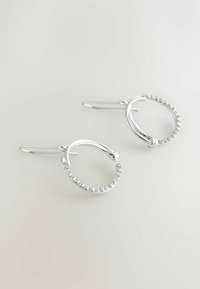 Pendientes de aro de plata con un diseño texturizado y una fila de pequeñas piedras de estrás a lo largo del borde exterior. Cuentan con un cierre de gancho.