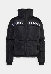 Giacca a vento nera con colletto alto, zip frontale e polsini a costine. Presenta il testo ricamato "KARL KANI" sul petto in bianco.