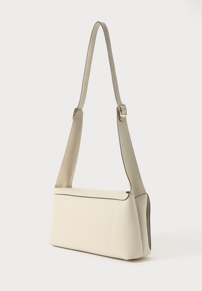 Borsa a tracolla in pelle beige con design piatto, tracolla regolabile e bordi neri a contrasto. Presenta una tasca anteriore e una superficie liscia.
