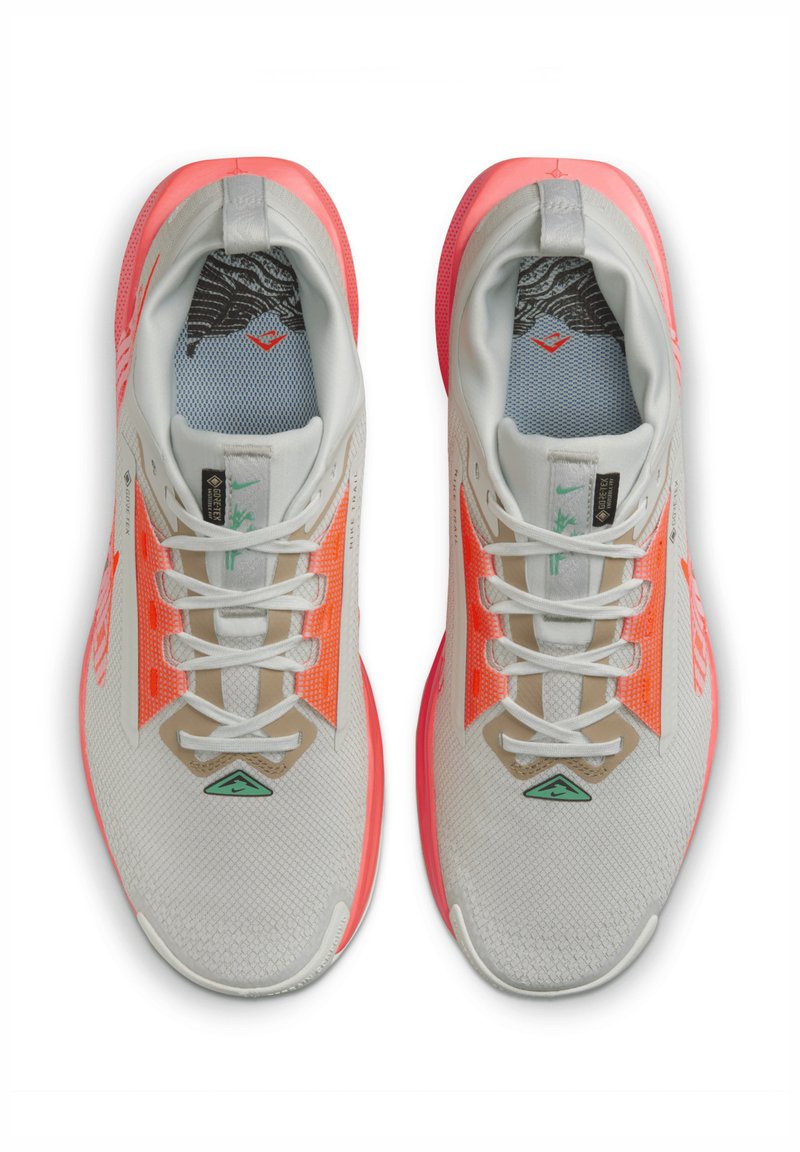 Zapatillas ligeras en gris y coral brillante, con una parte superior de malla, texturas contrastantes y detalles reflectantes en los cordones y los lados.