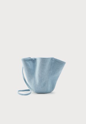 Light blue fabric bucket bag with long strap, wide top opening, and stitched vertical seams, set against a plain white background.