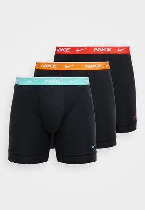 Τρία ζευγάρια μαύρα ανδρικά εσώρουχα Nike με ζωνάρια στη μέση σε χρώματα: μέντα, πορτοκαλί και κόκκινο. Το καθένα φέρει το λογότυπο της Nike σε λευκό χρώμα.