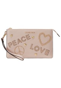 Sacoche beige Michael Kors avec des clous dorés formant les mots "PAIX" et "AMOUR", un symbole de paix, des formes de cœur et de petits cœurs dorés.