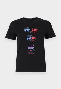 Černé bavlněné tričko s grafikou čtyř stylizovaných obličejů v brýlích v modré a červené barvě. Text ve spodní části zní "KARL LAGERFELD."