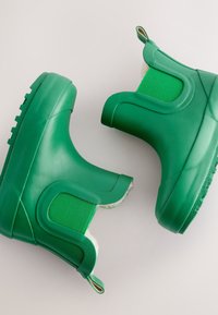 Stivali di gomma verdi con pannelli laterali testurizzati, design arrotondato e suola spessa. Presentano una linguetta per facilitare la calzata e una fodera interna morbida.