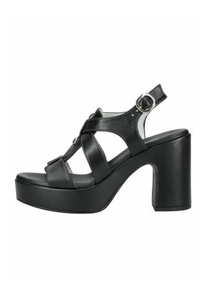 Sandalia de plataforma de cuero negro con puntera abierta, correas cruzadas, hebilla plateada en el tobillo y tacón alto grueso.