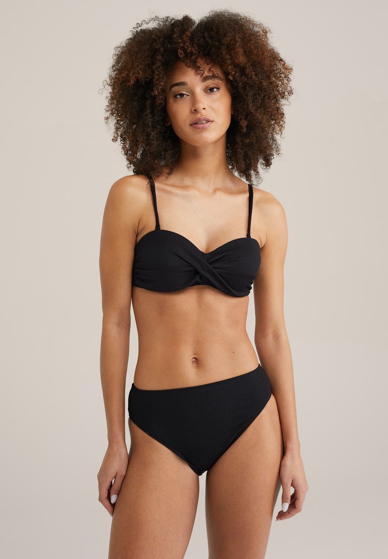 Črni dvodelni bikini set s povezanimi bandeau zgornjim delom in visokim pasom. Teksturna tkanina, tanke nastavljive naramnice in brezšivni robovi.