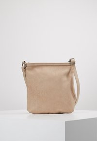 Borsa a tracolla in pelle beige con una texture morbida, forma rettangolare, una sola tracolla regolabile e una chiusura con zip sulla parte superiore.