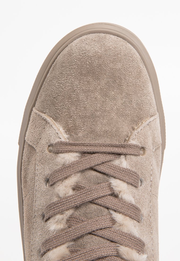 Beżowe zamszowe sneakersy z zaokrąglonym nosem, fakturowaną powierzchnią, płaskimi sznurowadłami i gumową podeszwą. Posiadają miękką wyściółkę wokół kostki.