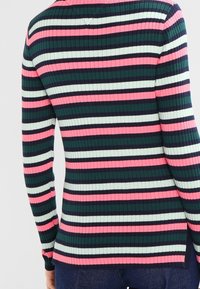 Sweter prążkowany w poziome paski w kolorze granatowym, różowym i jasnoszarym, o dopasowanym kształcie i bocznych rozcięciach dla dodatkowego efektu.