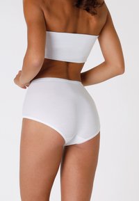 Top bandeau bianco in cotone e slip a vita alta, texture liscia, design aderente, senza motivi visibili o dettagli in metallo.