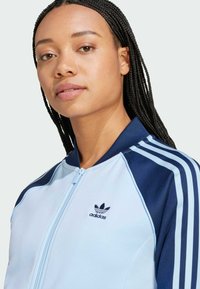 adidas Originals ADICOLOR CLASSICS SUPERSTAR TRACK - Vetoketjullinen college - clear sky