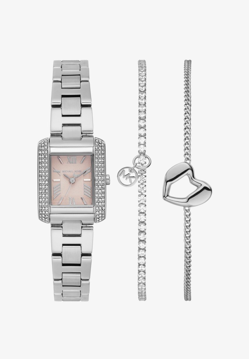 Reloj de metal plateado con esfera rectangular, dial rosa y acentos de cristal; incluye dos pulseras plateadas, una con un charm de corazón y otra con piedras claras.