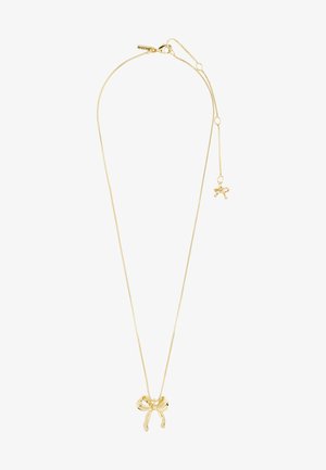 Zlatna ogrlica s delikatnom lancem i privjeskom u obliku mašne. Privjesak ima glatke, zakrivljene rubove i mali privjesak.