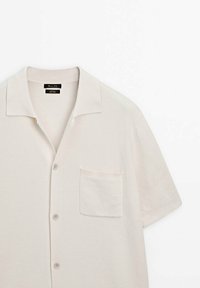 Korte mouwen, lichtbeige knoopshirt van gestructureerd materiaal, met een platte kraag en een enkele borstzak.