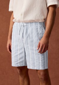 Lichtblauwe gestreepte shorts van gestructureerde stof, met een elastische tailleband en een trekkoord voor een verstelbare pasvorm.