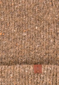 Brączowy, teksturowany czapka z włóczki o prążkowanym wzorze z pomarańczowymi i białymi plamkami. Zawiera małą brązową skórzaną metkę z logo.