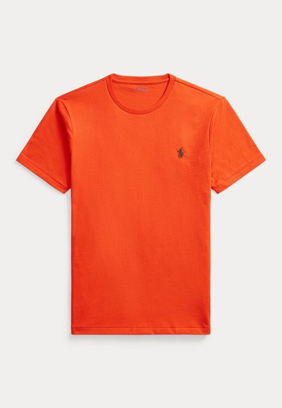 Trumpas rankovės oranžinės medvilnės marškinėliai su apvaliu kaklu ir mažyte siuvinėjimo logotipu ant krūtinės, pasižymintys lygiu paviršiumi ir standardiniu pajudėjimu.