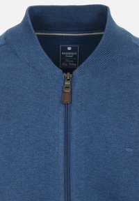 Blaue Strickjacke mit Reißverschluss und geripptem Kragen, ausgestattet mit einem Metallreißverschluss und einem Lederakzent. Enthält ein Logo-Tag im Nackenbereich.