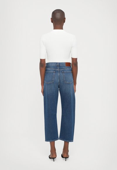 Bredde ben mørkeblå denim jeans med høj talje, der har to baglommer og et lædermærke på taljebåndet. Glat tekstur.